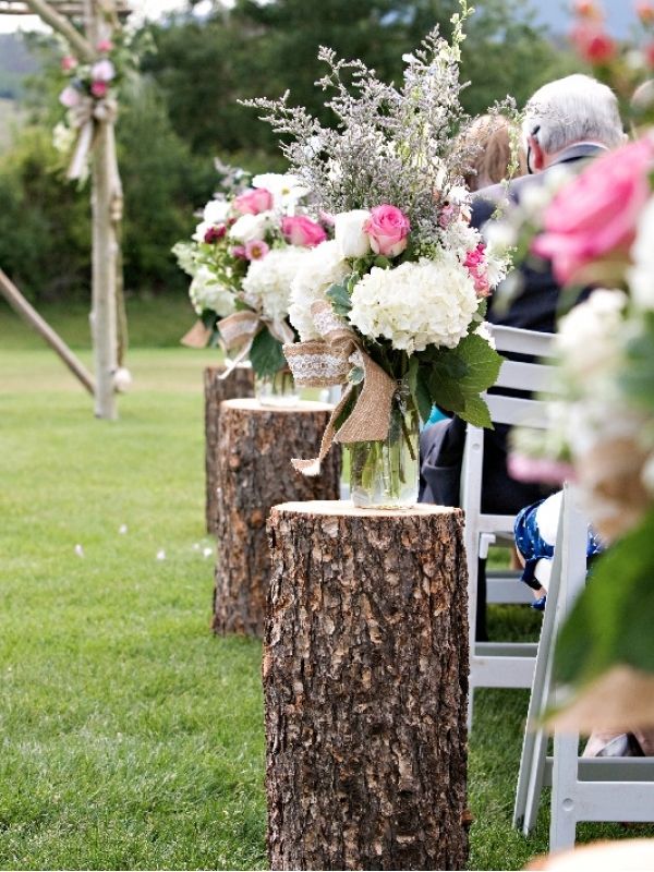 Social distancing from wedding aisle using
logs as flower stands and spacers