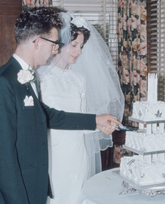 Vintage photograph of couple cutting a three
tier wedding cake